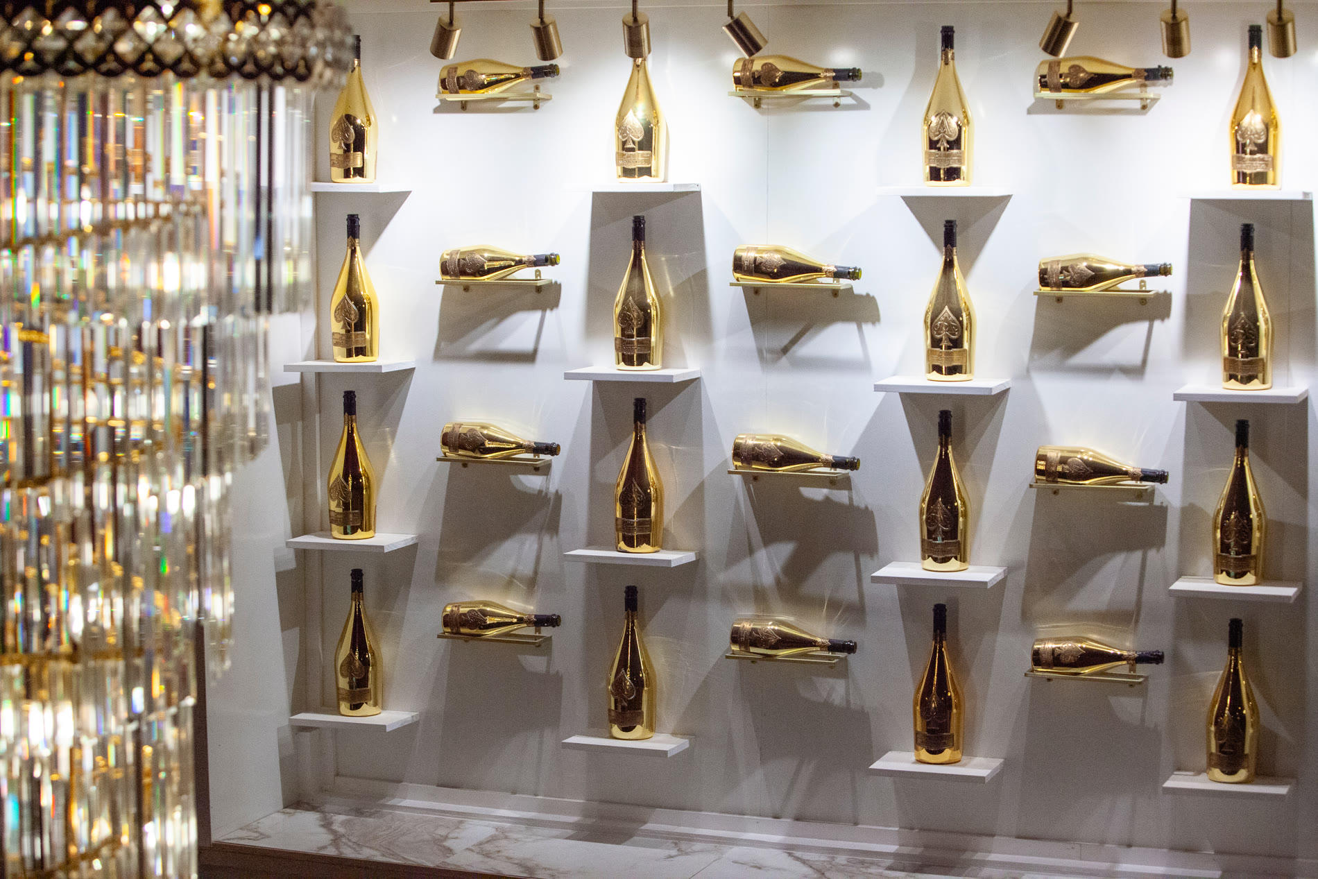 A wall of gold champagne bottles on display at Champagne Restaurant + Lounge